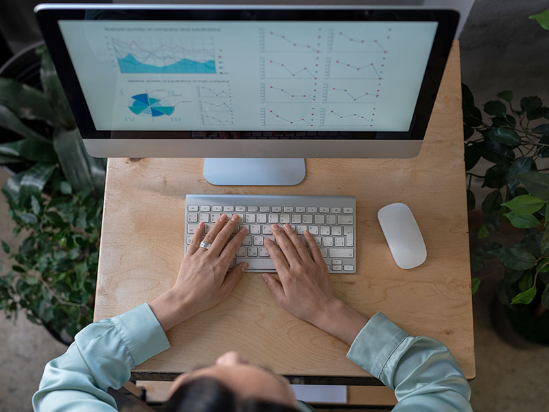 An overhead view of an employee looking at data on a computer screen.